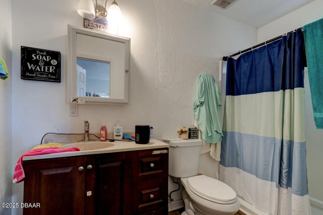 421 N Peninsula Dr, Daytona Beach, FL 32118 - full bathroom featuring toilet, vanity, a shower with shower curtain, and a textured wall