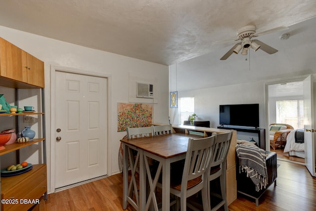 421 N Peninsula Dr, Daytona Beach, FL 32118 - dining area with light wood finished floors, a ceiling fan, and an AC wall unit