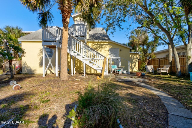 421 N Peninsula Dr, Daytona Beach, FL 32118 - back of house featuring stairs, stucco siding, a patio, and roof with shingles