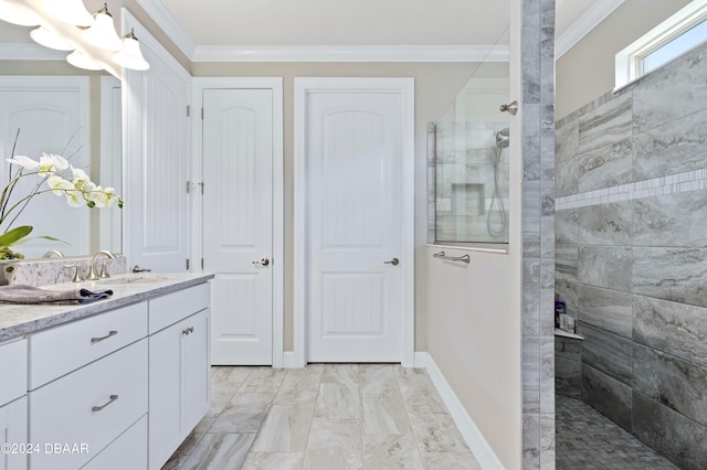 bathroom with vanity, a tile shower, and ornamental molding