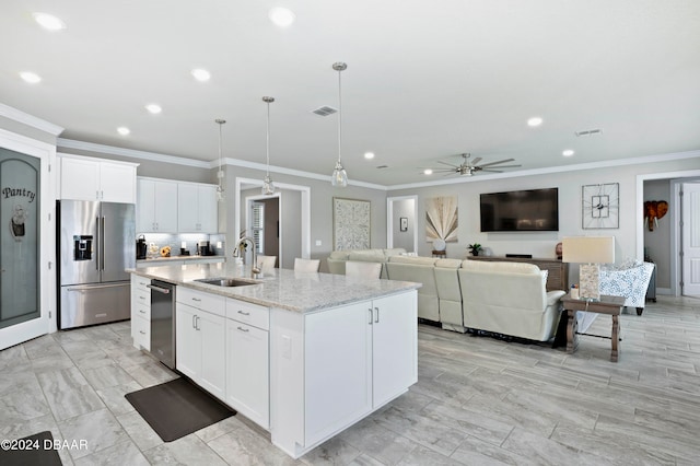 kitchen with white cabinets, stainless steel appliances, a center island with sink, and sink