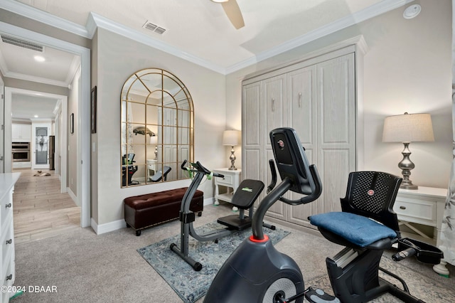 workout room featuring light colored carpet, ceiling fan, and crown molding