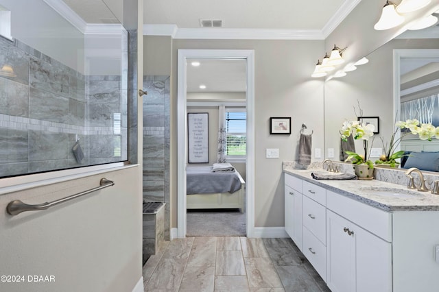 bathroom with vanity, tiled shower, and crown molding