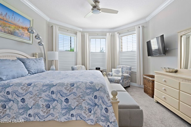 carpeted bedroom with a textured ceiling, ceiling fan, and crown molding