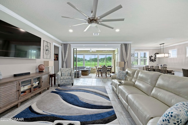 living room with a textured ceiling, ceiling fan, and ornamental molding