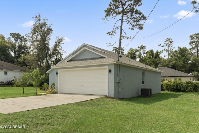 garage featuring central air condition unit and a lawn