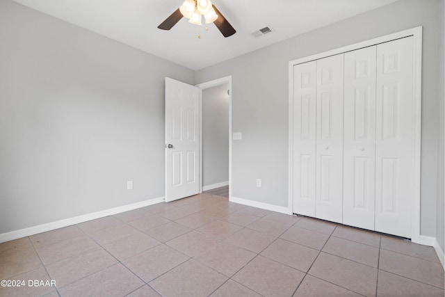 unfurnished bedroom with a closet, ceiling fan, and light tile patterned floors