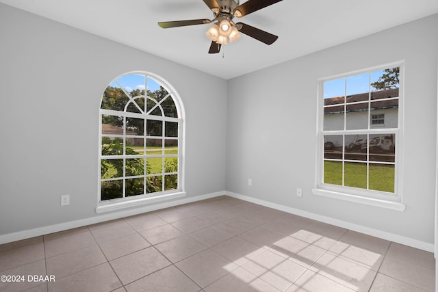 tiled spare room featuring ceiling fan