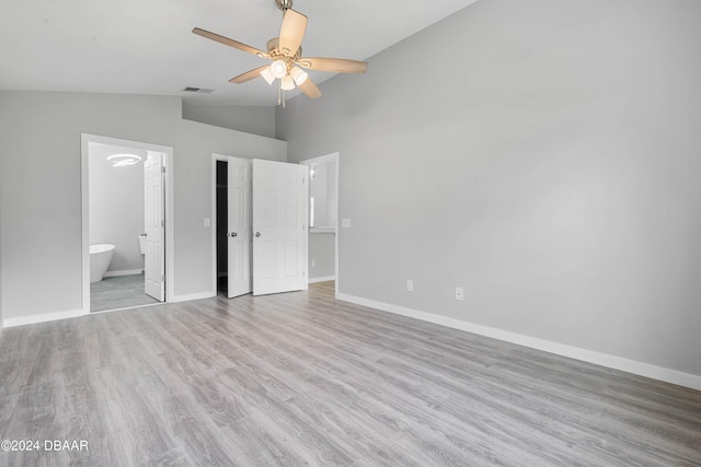 unfurnished bedroom featuring light hardwood / wood-style floors, vaulted ceiling, ceiling fan, and ensuite bathroom