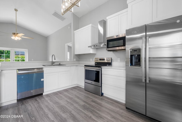 kitchen featuring white cabinets, stainless steel appliances, sink, and wall chimney range hood