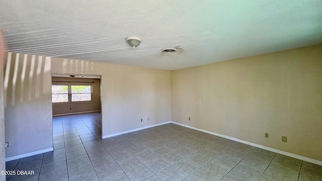 unfurnished room with baseboards, visible vents, a textured ceiling, and tile patterned floors