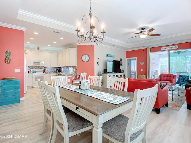 dining room with light hardwood / wood-style flooring, ornamental molding, and ceiling fan with notable chandelier