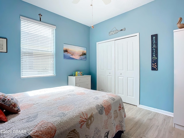 bedroom with ceiling fan, multiple windows, a closet, and light hardwood / wood-style flooring