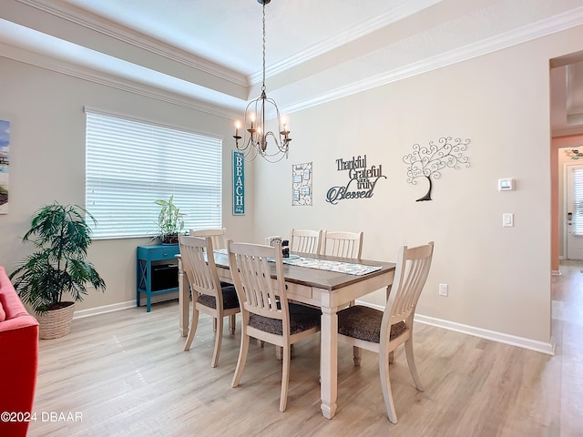 dining room with light hardwood / wood-style floors, crown molding, and an inviting chandelier