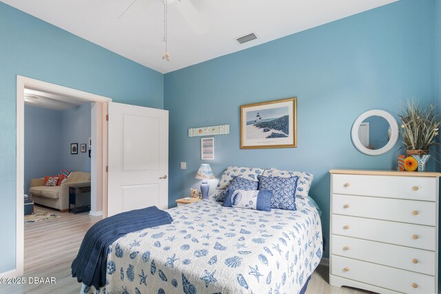 bedroom featuring light hardwood / wood-style floors, ceiling fan, and a closet