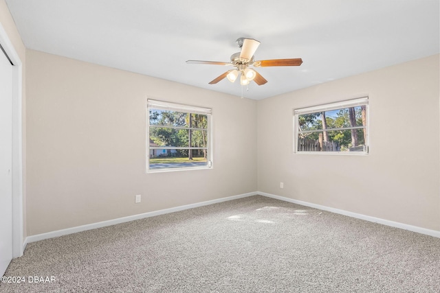 spare room featuring carpet, ceiling fan, and a healthy amount of sunlight