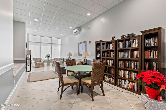 tiled dining room featuring a paneled ceiling, a towering ceiling, and a wall unit AC