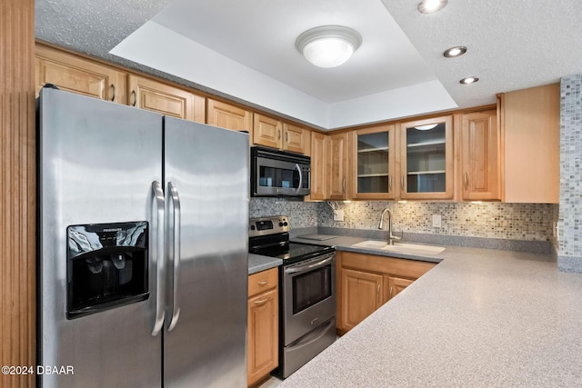 kitchen with a raised ceiling, sink, stainless steel appliances, and a textured ceiling