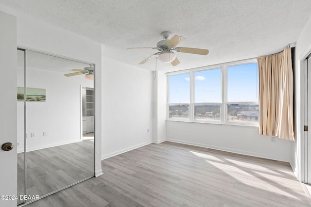 empty room featuring a textured ceiling and light wood-type flooring