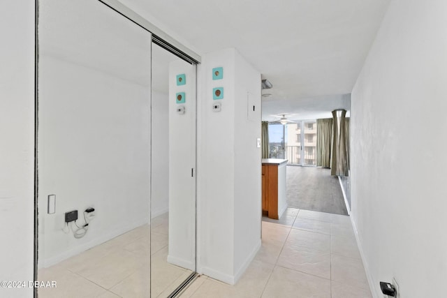 hall featuring light tile patterned floors and a wall of windows