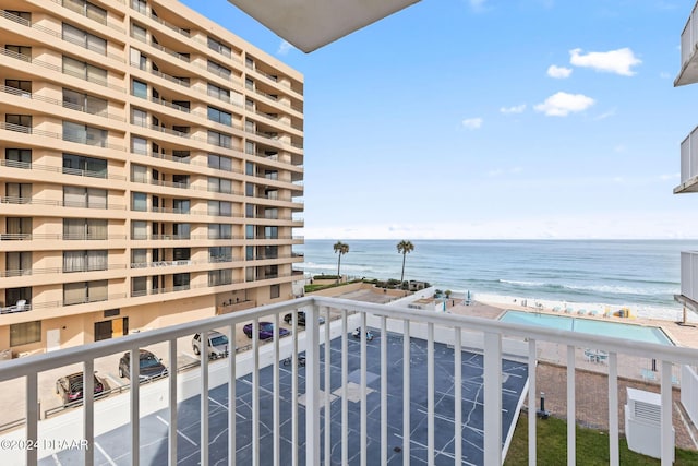 balcony featuring a view of the beach and a water view