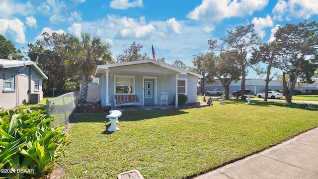 bungalow with central AC unit, a porch, and a front yard