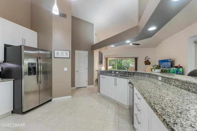 414 Long Cove Ct, Ormond Beach, FL 32174 - kitchen featuring appliances with stainless steel finishes, high vaulted ceiling, white cabinetry, light stone countertops, and light tile patterned flooring