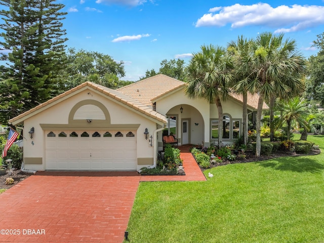 414 Long Cove Ct, Ormond Beach, FL 32174 - mediterranean / spanish house featuring stucco siding, a front lawn, decorative driveway, an attached garage, and a tiled roof