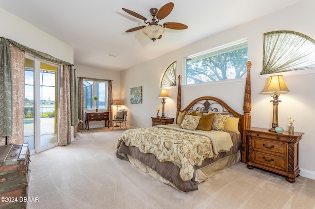 carpeted bedroom featuring ceiling fan, multiple windows, and access to outside