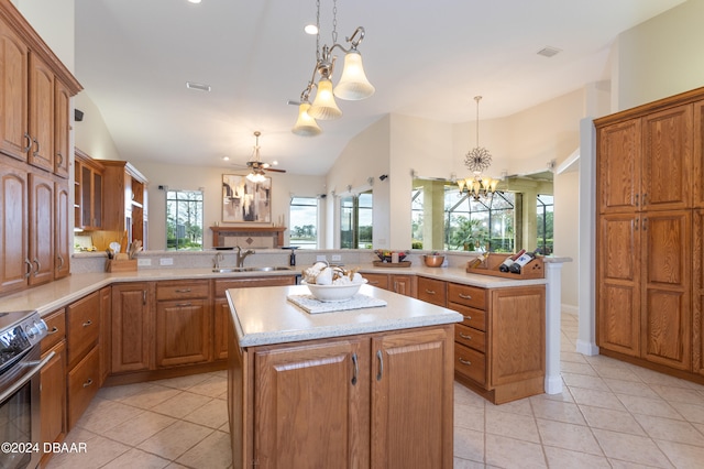 kitchen with sink, kitchen peninsula, hanging light fixtures, a kitchen island, and electric range