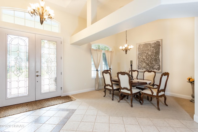 dining space with french doors, lofted ceiling, a chandelier, and light tile patterned floors