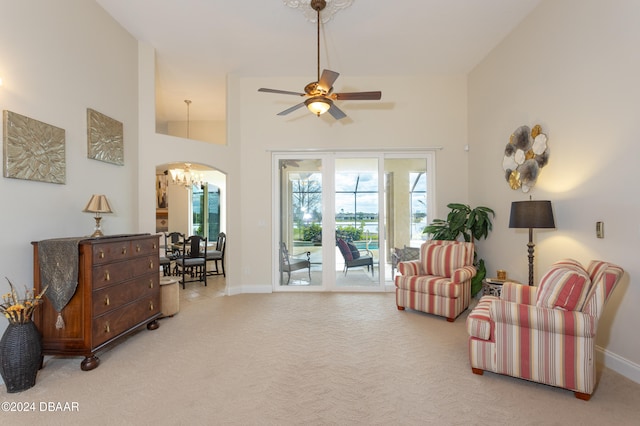 living area featuring ceiling fan, light colored carpet, and high vaulted ceiling