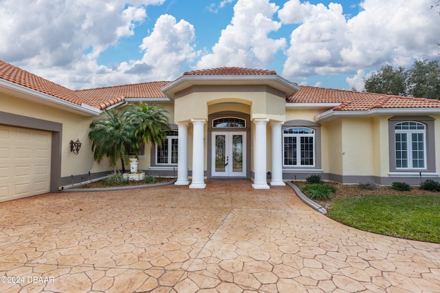 mediterranean / spanish-style home featuring a garage and french doors