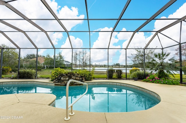 view of pool with a lanai, a water view, and a patio