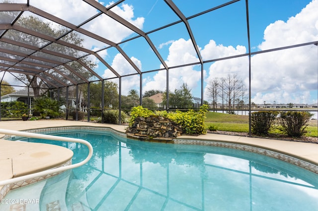 view of pool with glass enclosure and a patio area