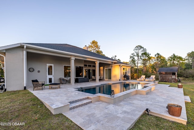 view of swimming pool featuring an outdoor fire pit, a patio, a jacuzzi, and a storage shed