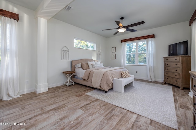 bedroom with ceiling fan, light wood-type flooring, and multiple windows