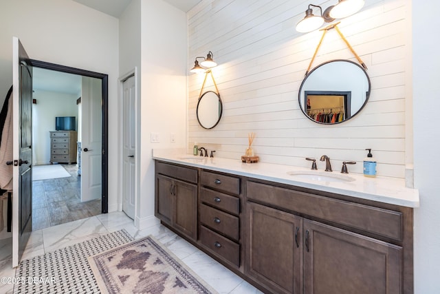 bathroom featuring vanity and wood walls