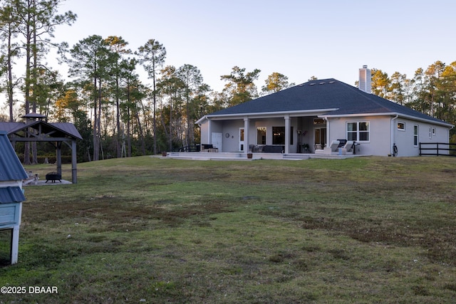 back of house with a lawn, a patio area, and a gazebo