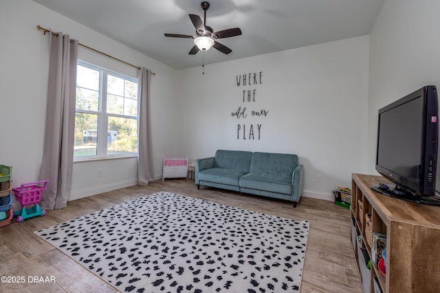 sitting room with ceiling fan and light wood-type flooring