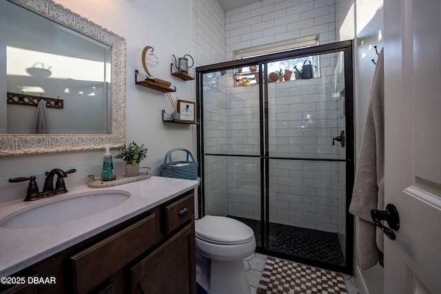 bathroom with toilet, a shower with door, tile patterned floors, and vanity