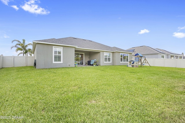 1602 Killian Drive Ne, Palm Bay, FL 32905 - back of property featuring a playground, a fenced backyard, stucco siding, and roof with shingles