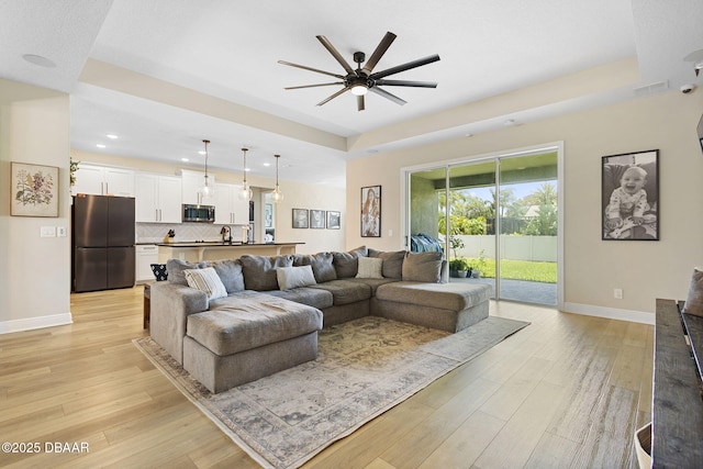 1602 Killian Drive Ne, Palm Bay, FL 32905 - living room with light wood-style flooring, ceiling fan, recessed lighting, and a tray ceiling