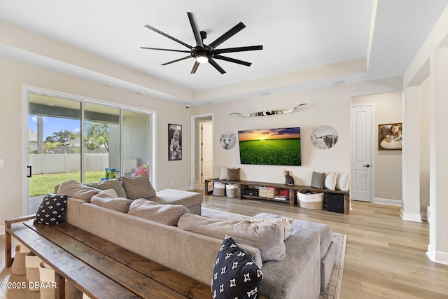 1602 Killian Drive Ne, Palm Bay, FL 32905 - living room featuring a tray ceiling, light wood finished floors, and a ceiling fan