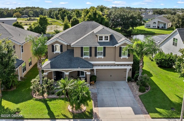 view of front of home featuring a garage, stucco siding, driveway, and roof with shingles