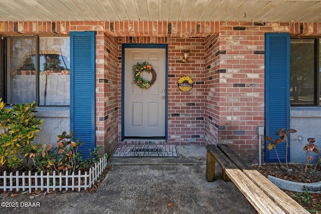 view of exterior entry featuring brick siding