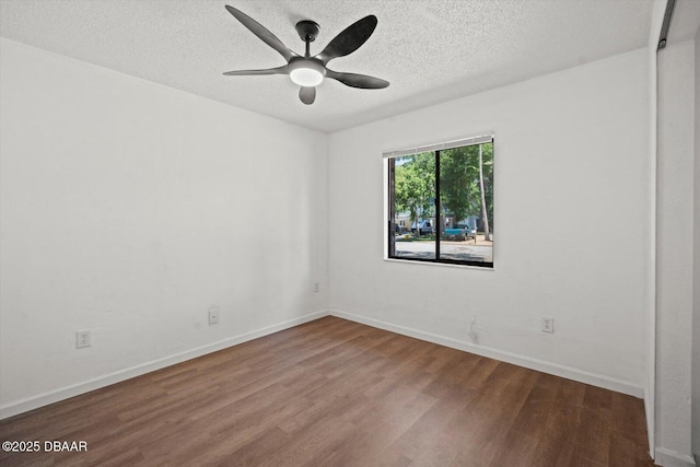 unfurnished room with baseboards, a ceiling fan, wood finished floors, and a textured ceiling