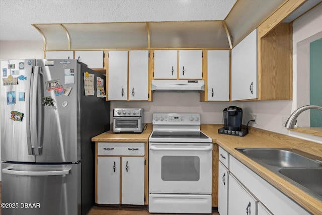 kitchen with freestanding refrigerator, under cabinet range hood, light countertops, a sink, and white electric stove