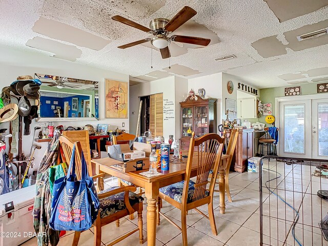 dining space with a textured ceiling and light tile patterned floors