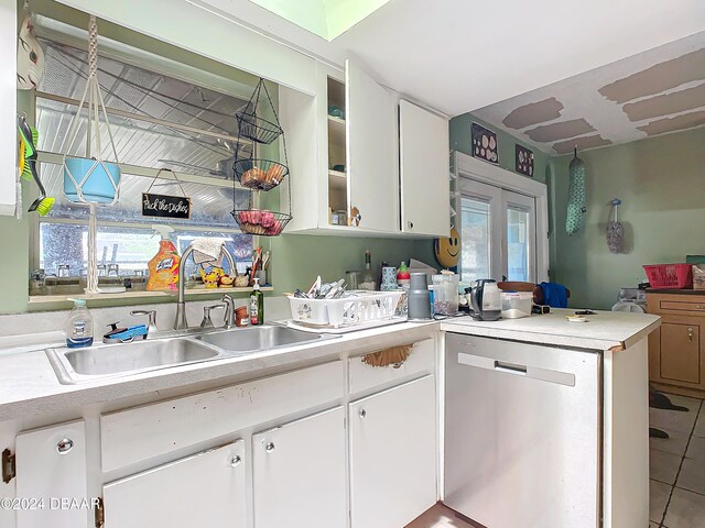 kitchen featuring stainless steel dishwasher, tile patterned flooring, white cabinets, and sink